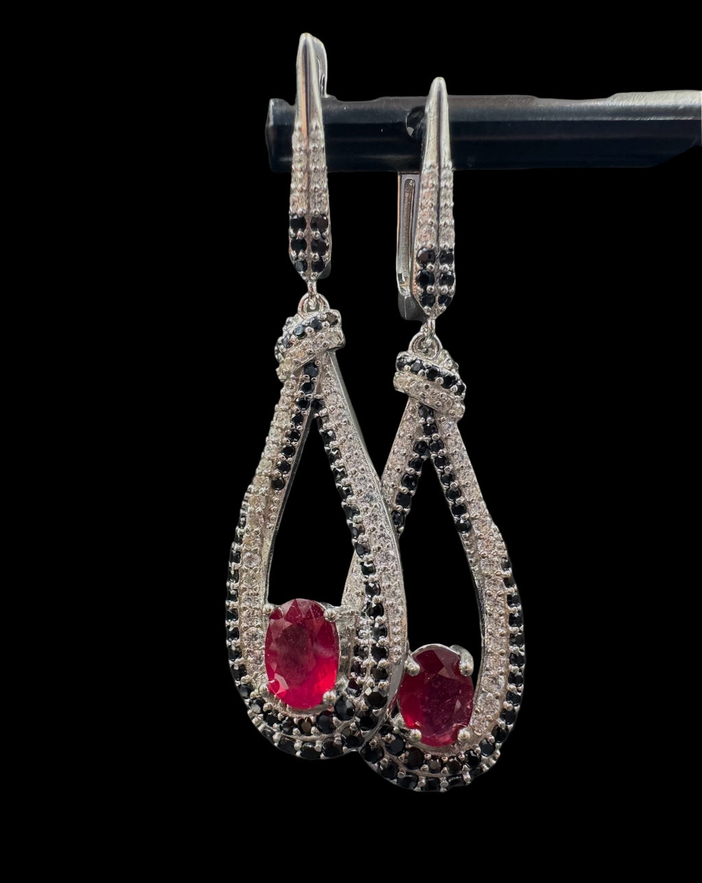 Pair of earrings with red gemstones on a black background